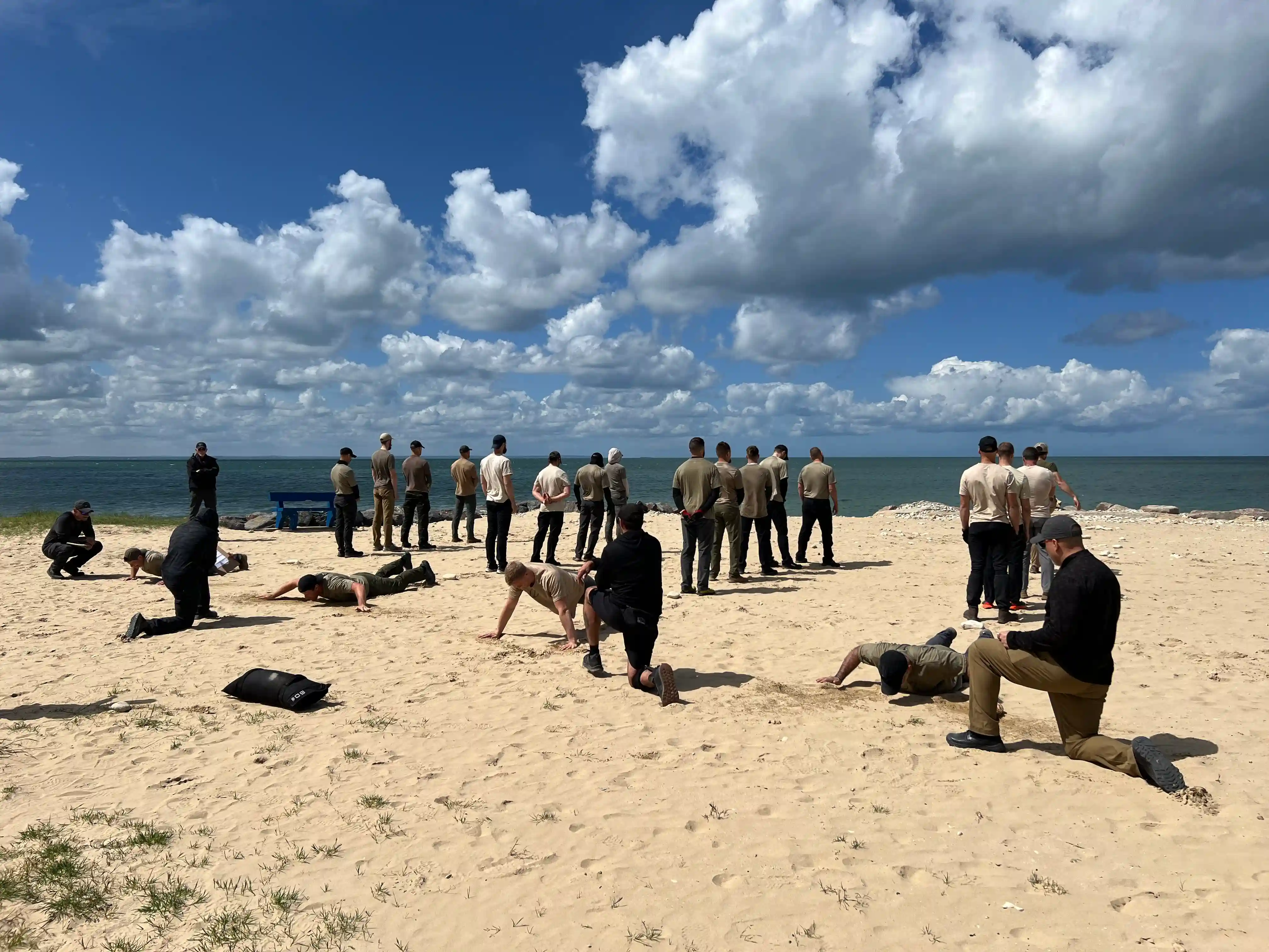 Some candidates are being tested on push ups while the rest face the bay