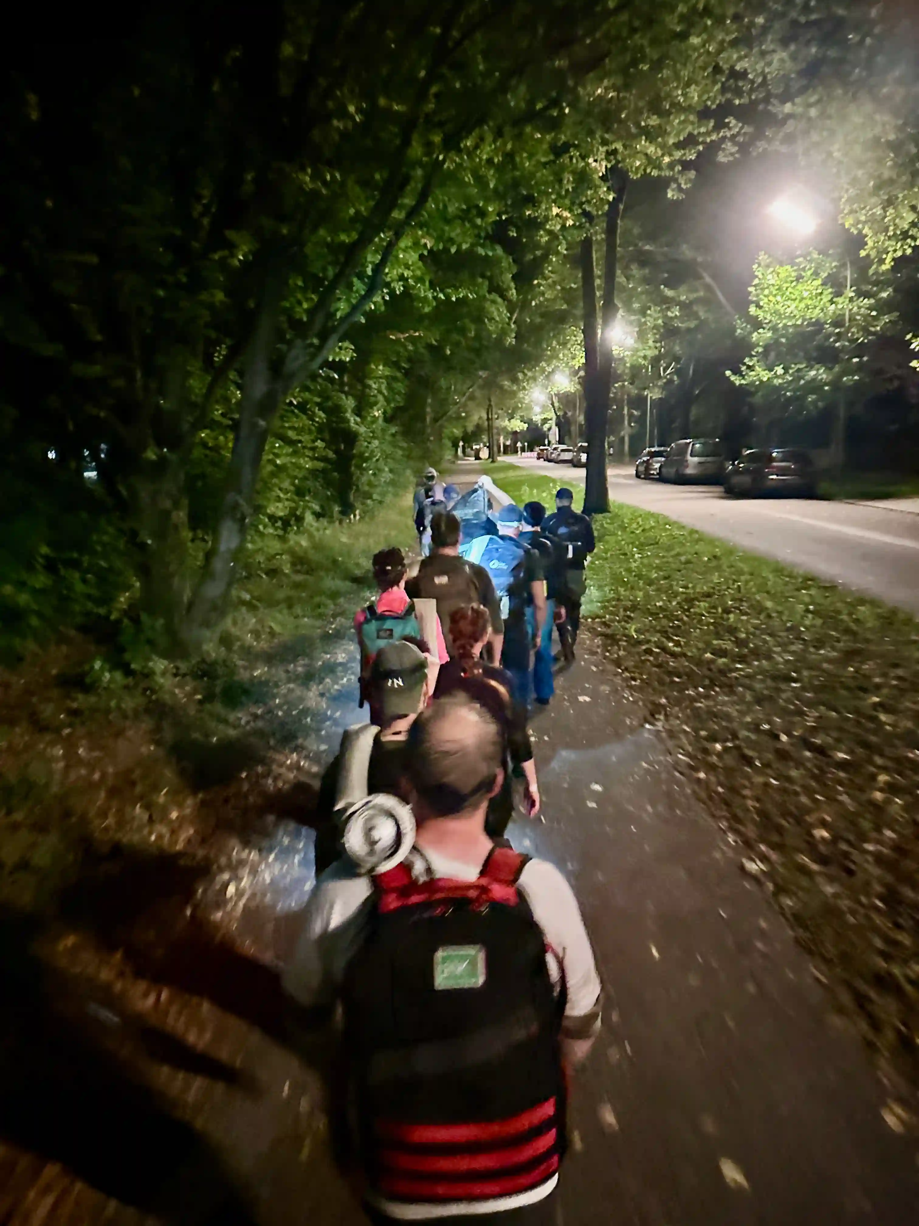 The team walking westwards while carrying the fire hose on their shoulders.