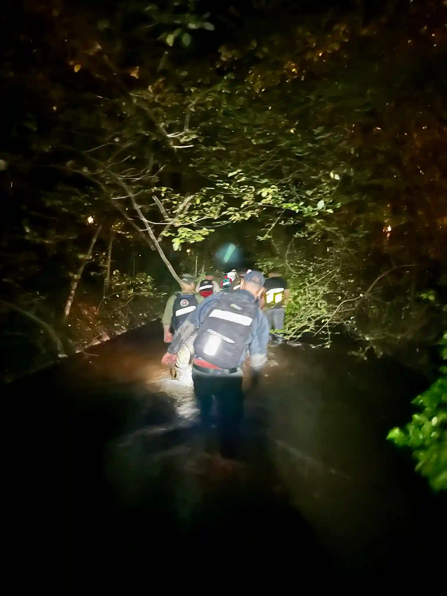 The team wading silently through the stream.